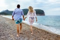 Young couple laughing and holding hands on the beach Royalty Free Stock Photo