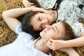 Happy young couple lie in straw, wheaten field at evening, romantic people concept, beautiful landscape, summer season Royalty Free Stock Photo