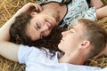 Happy young couple lie in straw, wheaten field at evening, romantic people concept, beautiful landscape, summer season Royalty Free Stock Photo