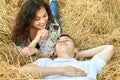 Happy young couple lie in straw, wheaten field at evening, romantic people concept, beautiful landscape, summer season Royalty Free Stock Photo