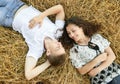 Happy young couple lie in straw, wheaten field at evening, romantic people concept, beautiful landscape, summer season Royalty Free Stock Photo