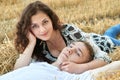 Happy young couple lie in straw, wheaten field at evening, romantic people concept, beautiful landscape, summer season Royalty Free Stock Photo