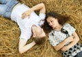 Happy young couple lie in straw, wheaten field at evening, romantic people concept, beautiful landscape, summer season Royalty Free Stock Photo