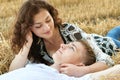 Happy young couple lie in straw, wheaten field at evening, romantic people concept, beautiful landscape, summer season Royalty Free Stock Photo