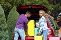 Happy young couple loading suitcases in car trunk Royalty Free Stock Photo