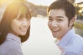 Happy Young Couple Looking at the Camera by a River Royalty Free Stock Photo