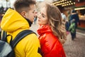 Happy young couple looking at each other with smile, wearning in bright yellow and red down jackets. Royalty Free Stock Photo