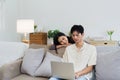 Happy young couple looking laptop relax on sofa in living room watch video on laptop together Royalty Free Stock Photo