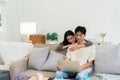 Happy young couple looking laptop relax on sofa in living room watch video on laptop together Royalty Free Stock Photo