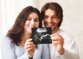Happy young couple looking at sonography picture of their baby Royalty Free Stock Photo