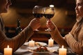 Happy young couple in love drinking wine and clinking glasses having romantic dinner Royalty Free Stock Photo