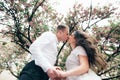 Happy young couple in love enjoys spring day, loving man holding on hands his woman carefree walking at park Royalty Free Stock Photo