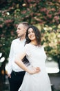 Happy young couple in love enjoys spring day, loving man holding on hands his woman carefree walking at park Royalty Free Stock Photo