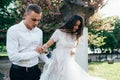 Happy young couple in love enjoys spring day, loving man holding on hands his woman carefree walking at park Royalty Free Stock Photo