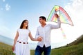 Happy young couple in love with flying a kite Royalty Free Stock Photo