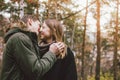 Happy young couple in love friends dressed in casual style kissing in nature park forest in cold season, family advenure travel Royalty Free Stock Photo