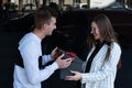 Happy young couple in love with gift. Guy makes gift to his beloved