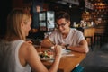 Happy young couple in love having a nice date in a bar or restaurant. They telling some stories about themself Royalty Free Stock Photo