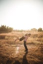 Happy young couple in love, hugging, she is jumping,he is holding her in embrace, enjoying outdoors in a wheat field at sunset Royalty Free Stock Photo