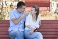 Happy young couple in love sitting on a park bench Royalty Free Stock Photo