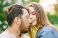 Happy young couple in love smiling and enjoying a walk in the summer Park. Romance and the concept of rest. Girl affectionately ca