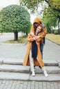 Happy young couple in love teenagers friends dressed in casual style sitting together on autumn city street Royalty Free Stock Photo