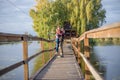 Happy young couple in love walking in bridge at sunset. Man embracing and going to kiss sensual woman Royalty Free Stock Photo