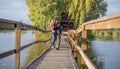 Happy young couple in love walking in bridge at sunset. Man embracing and going to kiss sensual woman Royalty Free Stock Photo