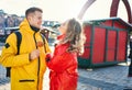 Happy young couple in love walking city street, looking at each other with smile, wearning in bright yellow and red down Royalty Free Stock Photo