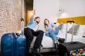 A happy young couple lying on the bed in a modern style hotel room. Big suitcases near the bed. Man holding his hand up Royalty Free Stock Photo