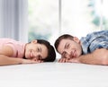 Happy young couple, lying on the floor, look at each other and dream of furniture for a new apartment. Mock up Royalty Free Stock Photo