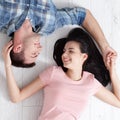 Happy young couple, lying on the floor, look at each other and dream of furniture for a new apartment. Mock up Royalty Free Stock Photo