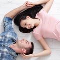 Happy young couple, lying on the floor, look at each other and dream of furniture for a new apartment. Mock up Royalty Free Stock Photo