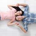 Happy young couple, lying on the floor, look at each other and dream of furniture for a new apartment. Mock up Royalty Free Stock Photo