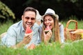 Happy young couple lying next to each other on a picnic blanket and eating watermelons Royalty Free Stock Photo