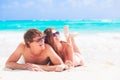 Happy young couple lying on a tropical beach in