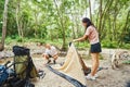 Happy young couple making camp in forest