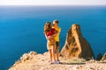 Happy young couple man and woman embrace on the edge of a cliff on the Cape, family youth travel concept