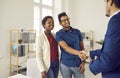 Happy young couple meeting and shaking hands with a real estate agent or loan broker Royalty Free Stock Photo