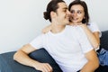 Happy young couple of man and woman embracing look at each other sitting on couch in living room Royalty Free Stock Photo