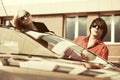 Happy young couple next to convertible car