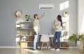 Happy young couple operating air conditioner at home Royalty Free Stock Photo