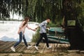 Happy young couple outdoors. young love couple running along a wooden bridge holding hands Royalty Free Stock Photo