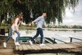 Happy young couple outdoors. young love couple running along a wooden bridge holding hands Royalty Free Stock Photo