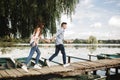 Happy young couple outdoors. young love couple running along a wooden bridge holding hands. Royalty Free Stock Photo