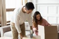 Happy young couple packing belonging in cardboard boxes, moving day Royalty Free Stock Photo