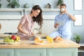 Happy young couple in pajamas watching online content in a didital tablet and smiling in kitchen at home Royalty Free Stock Photo