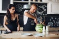 Handsome man cutting watermelon and sharing it with wife.