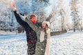 Happy young couple playing with snow in winter park. Man and woman having fun outdoors. Royalty Free Stock Photo