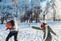 Happy young couple playing with snow in winter park. Man and woman having fun outdoors. Royalty Free Stock Photo